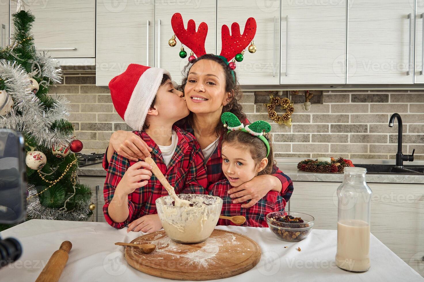 files/happy-mother-hugs-her-adorable-kids-all-dressed-in-red-and-green-plaid-clothes-cute-son-young-teenager-kissing-mom-on-cheek-while-cooking-together-and-recording-video-for-christmas-fo.jpg